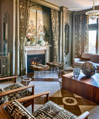 Living room with taupe walls gallery wall of paintings in gilt frames and marble floor